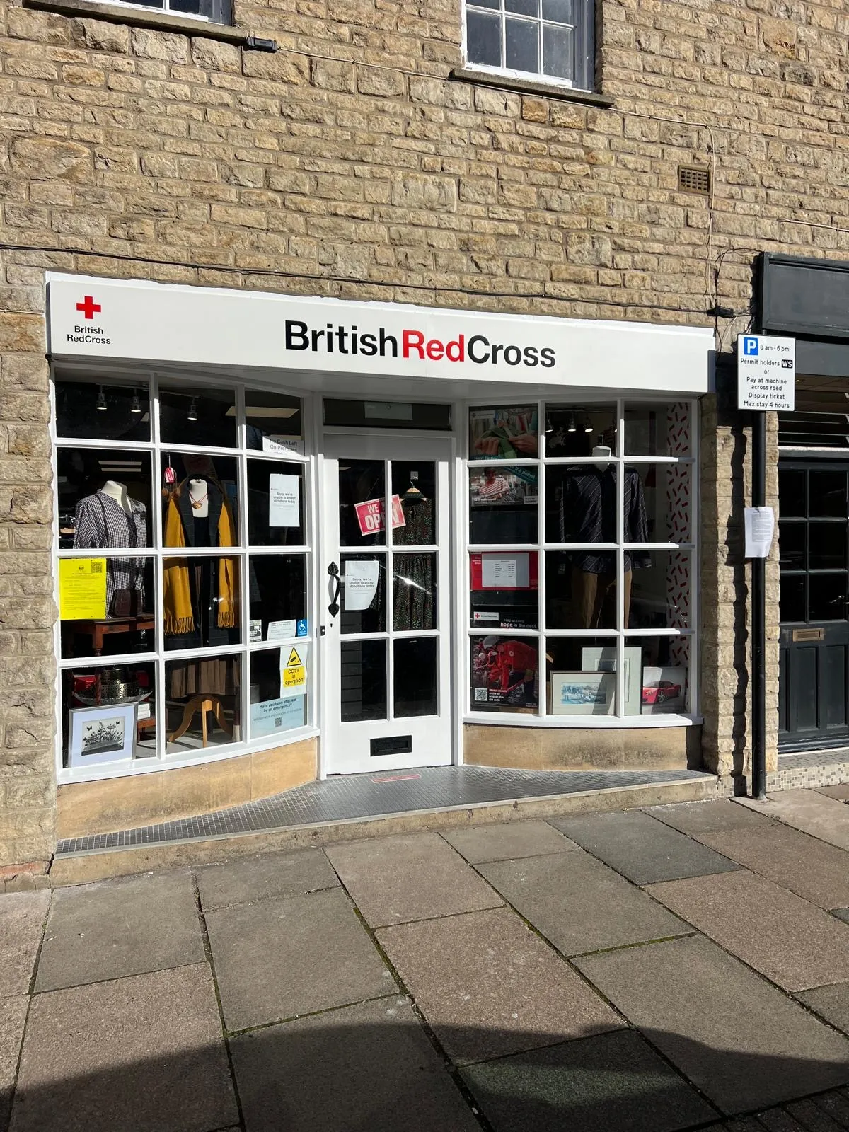 Shop front with painted window frames and door on a stone building